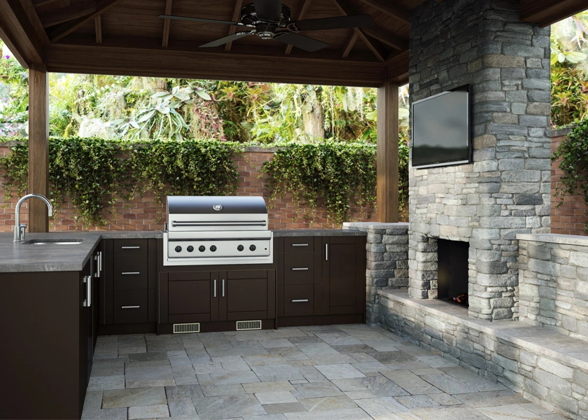 Outdoor kitchen with a stone fireplace in a covered pavilion
